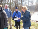 From left to right, John, Kim and Laura examine benthic invertebrate ID sheets.